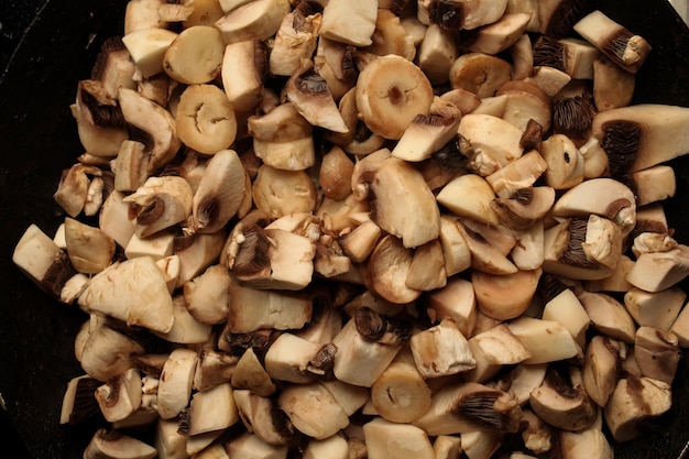 morceaux de champignons dans une poêle morceaux de champignons crus dans une poêle cuisson de champignons crus