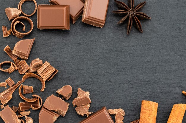 Photo morceaux de chocolat cassés et copeaux de chocolat sur un fond noir