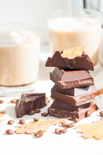 Morceaux de chocolat, grains de café et tasses de cacao ou café au lait. Concept d'automne.