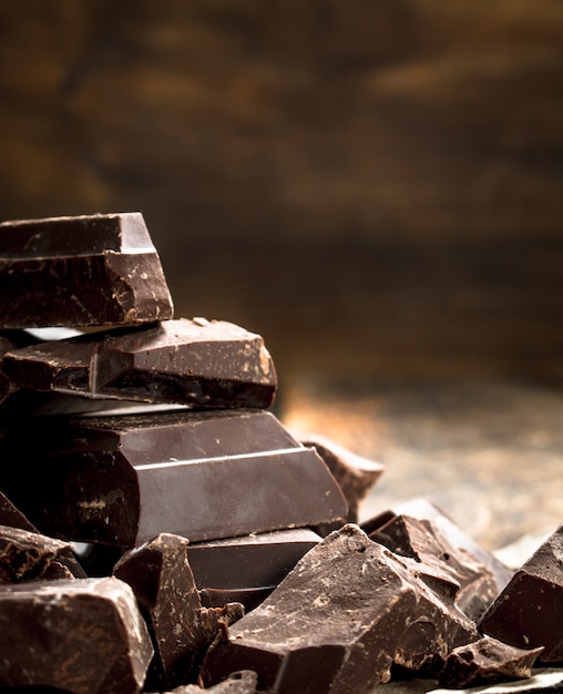 Morceaux de chocolat noir. Sur une table en bois.