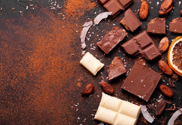 Morceaux de chocolat et poudre de cacao sur marbre. Les morceaux de chocolat sur fond sombre