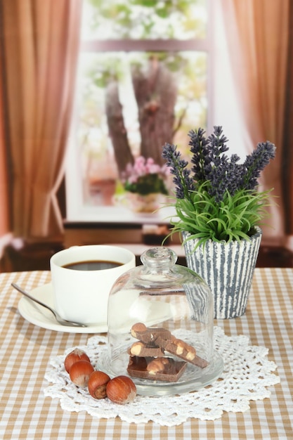 Morceaux de chocolat sous verre et boisson chaude sur fond clair