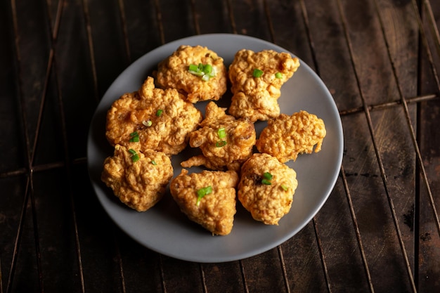 Morceaux de chou-fleur frit avec des sauces végétaliennes sur une assiette sur un fond sombre Ailes de chou-fleur alimentaire