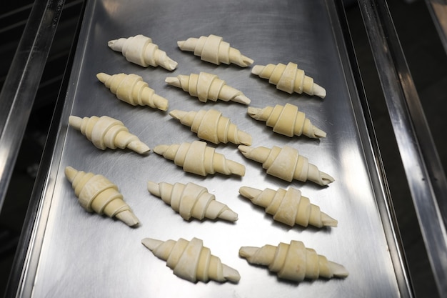 Morceaux de croissants surgelés sur une plaque à pâtisserie