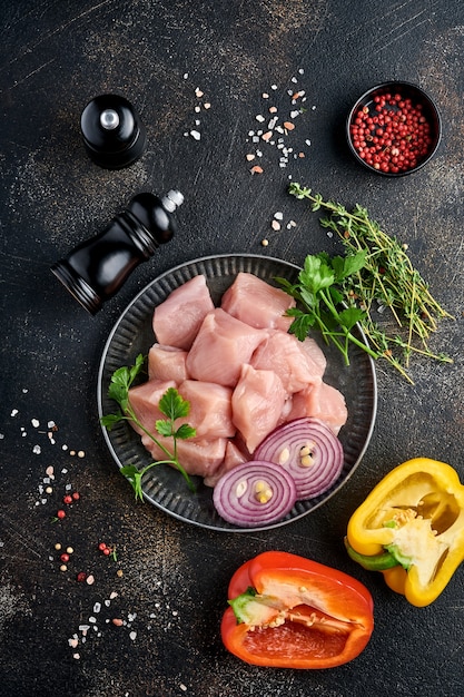 morceaux crus d'ingrédients de viande de poulet sur planche de bois, épices, herbes et légumes