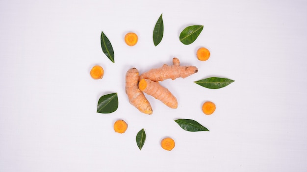 Morceaux De Curcuma Et Feuilles De Citron Vert Arrangés De Manière Intéressante Isolés Sur Fond Blanc