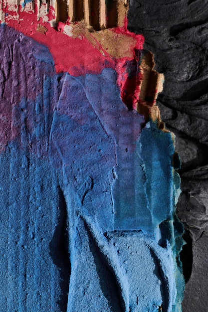 Morceaux déchiquetés multicolores bleus de carton fond abstrait tirets et traits de peinture chaotiques sur le plâtre appliqué avec la texture du mastic à la spatule