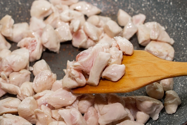 Morceaux de filet de poulet frits dans une poêle. Le processus de cuisson se bouchent.