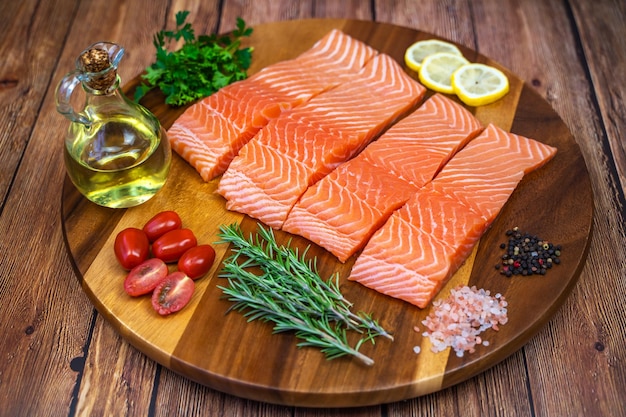 Photo morceaux de filet de saumon aux épices et huile d'olive sur une planche de bois.