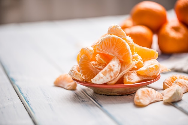 Morceaux frais de mandarines mandarines sur l'assiette ou dans un bol.
