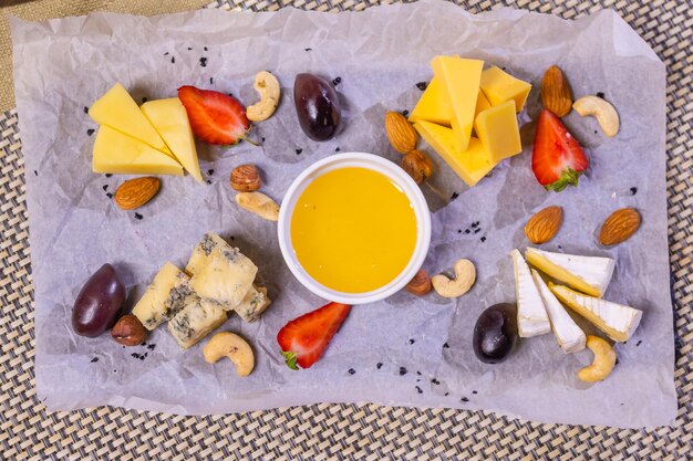 Morceaux de fromage salés servis avec noix et romarin