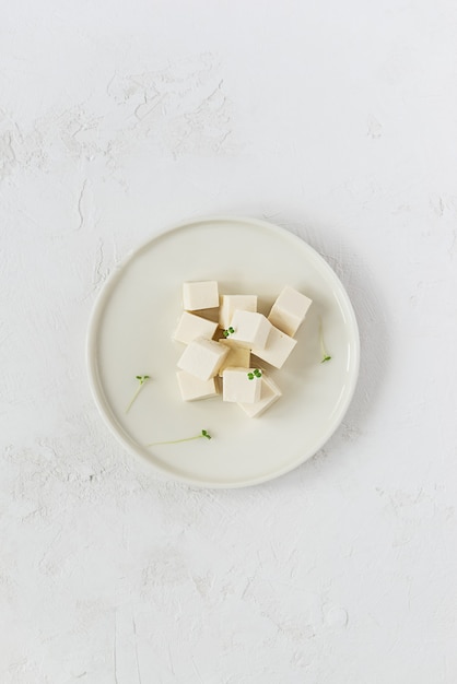 Morceaux de fromage de tofu avec micro greens sur une assiette