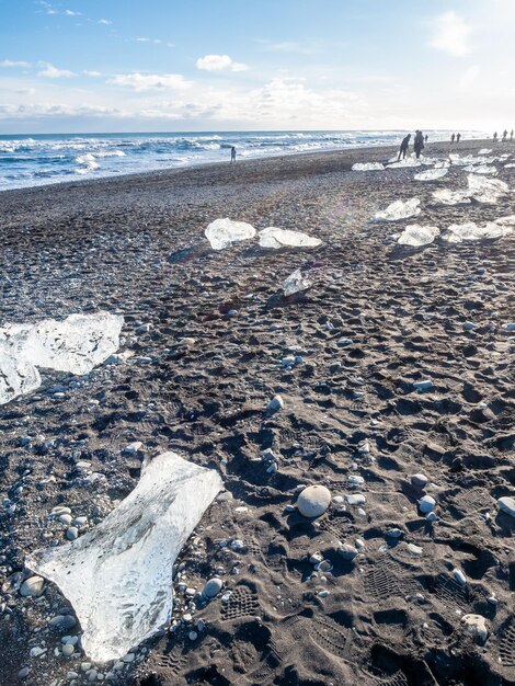 Des morceaux de glace scintillent comme des diamants sur une plage de sable noir en hiver en Islande