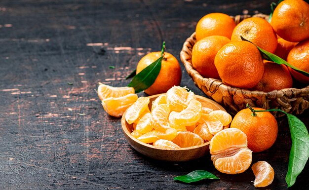 Morceaux de mandarines fraîches sur une assiette avec des feuilles