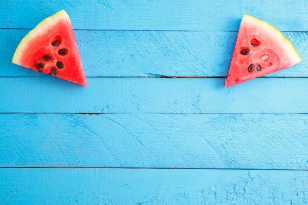 Morceaux de melon d'eau rouge écarlate sur fond vintage en bois bleu.