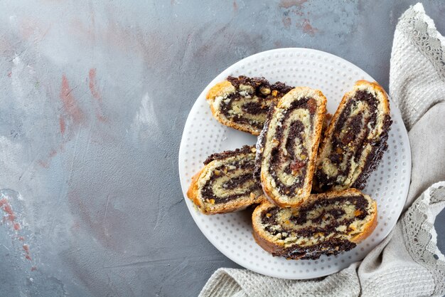 Morceaux de miel avec des graines de pavot et des raisins secs sur un plateau blanc