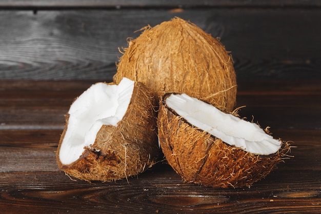 Morceaux de noix de coco fissurés sur un fond en bois foncé