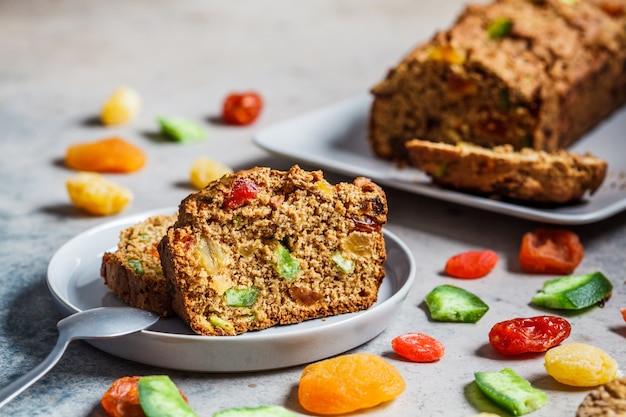 Morceaux de pain aux fruits secs sur une assiette grise.