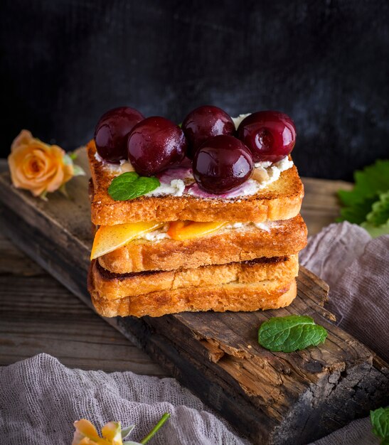 Morceaux de pain blanc frits avec du caillé doux et des cerises