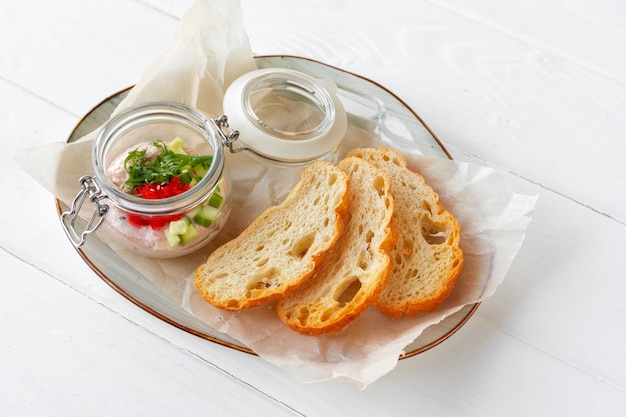 Morceaux de pain avec pâté de poisson sur table en bois blanc