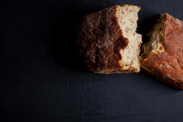 Morceaux de pain avec son et graines, sur fond sombre. Photo en gros plan, mise au point douce. Nourriture saine.