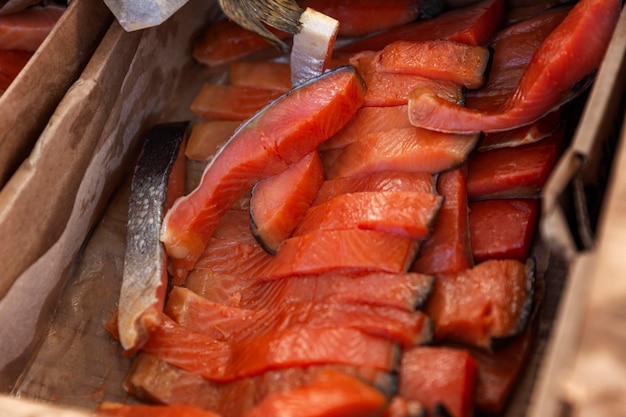 Des morceaux de poisson fumé rouge dans une boîte au marché Morkoy est une délicieuse délicatesse alimentaire Closeup