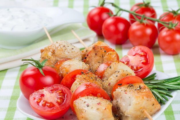 Morceaux de poulet grillés en brochettes avec des tomates