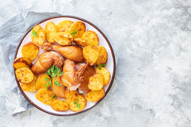 Morceaux de poulet et pommes de terre frites légumes au four plat de viande de volaille