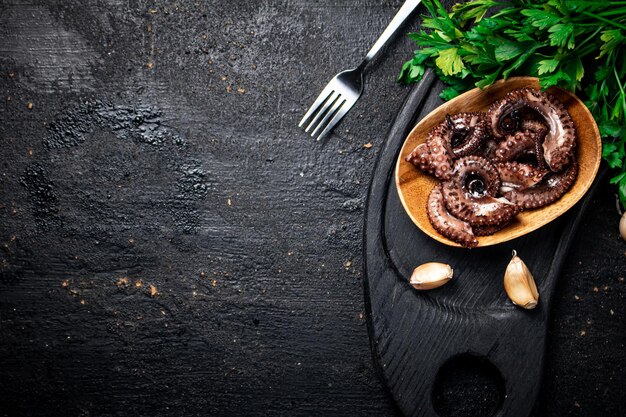 Morceaux de poulpe sur une planche à découper avec du persil