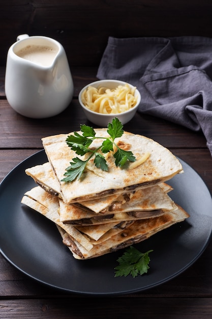 Morceaux de quesadilla aux champignons, crème sure et fromage