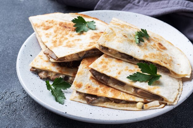 Morceaux de quesadilla aux champignons, sauce à la crème et fromage