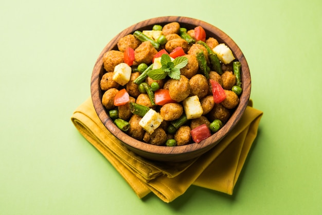 Morceaux de soja Masala Fry OU Meal Maker Fry en utilisant du paneer ou des cubes de fromage cottage et des légumes. Recette de collation saine populaire d'Inde. Servi dans un bol. Mise au point sélective