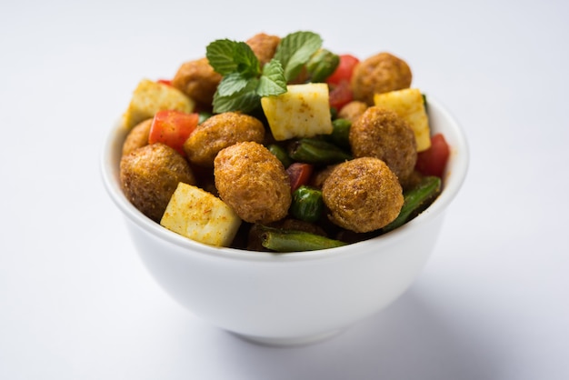 Morceaux de soja Masala Fry OU Meal Maker Fry en utilisant du paneer ou des cubes de fromage cottage et des légumes. Recette de collation saine populaire d'Inde. Servi dans un bol. Mise au point sélective