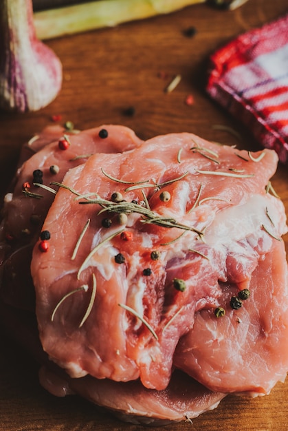 Morceaux de steak de porc cru aux épices et herbes romarin, thym, basilic, sel et poivre