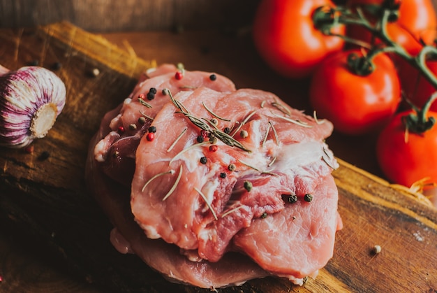 Morceaux de steak de porc cru aux épices et herbes romarin, thym, basilic, sel et poivre