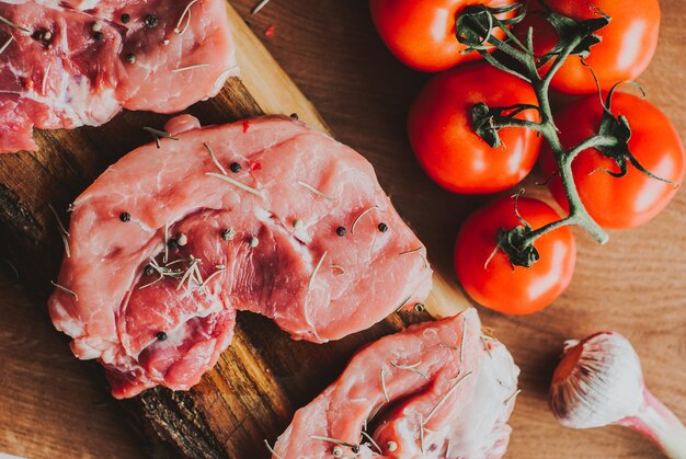 Morceaux de steak de porc cru aux épices et herbes romarin, thym, basilic, sel et poivre