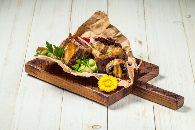 Morceaux de viande de boeuf grillé rôti sur planche de bois