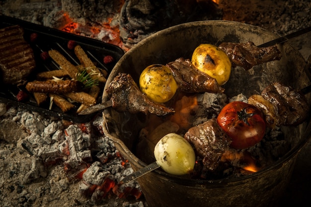 Photo morceaux de viande à la tomate et au citron cuits sur des charbons ardents le plat est cuit et fumé sur du charbon de bois