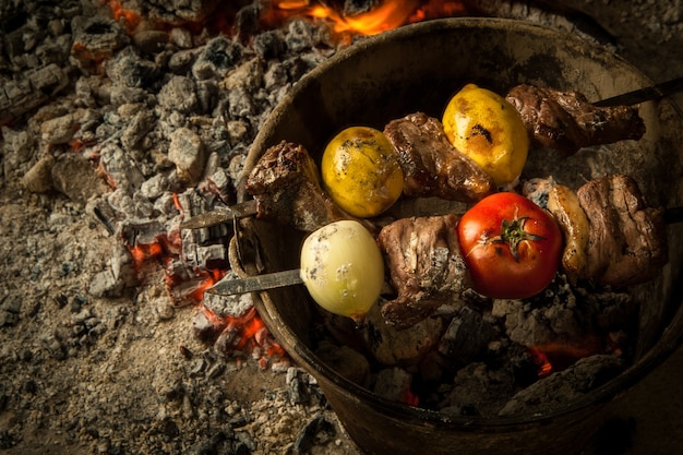 Morceaux de viande à la tomate et au citron cuits sur des charbons ardents Le plat est cuit et fumé sur du charbon de bois