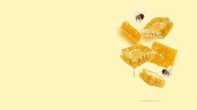 Morceaux volants de nid d'abeilles goutte de miel et d'abeilles sur fond jaune Une composition conceptuelle de nids d'abeilles flottants Image carrée d'aliments sains Espace de copie de conception de mise en page créative