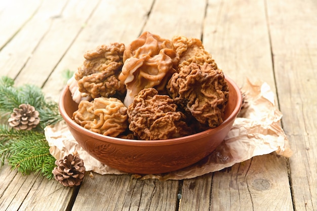 Photo morilles dans un bol en céramique brune sur une table en bois. extérieur.