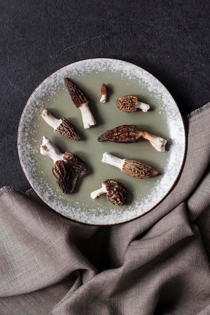 Morilles sur une plaque sur fond noir