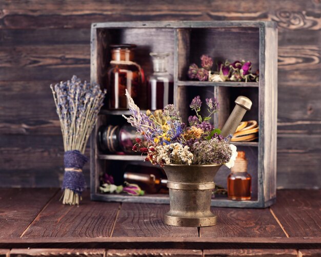 Mortier d'herbes médicinales et teinture de bouteilles dans une boîte en bois Phytothérapie