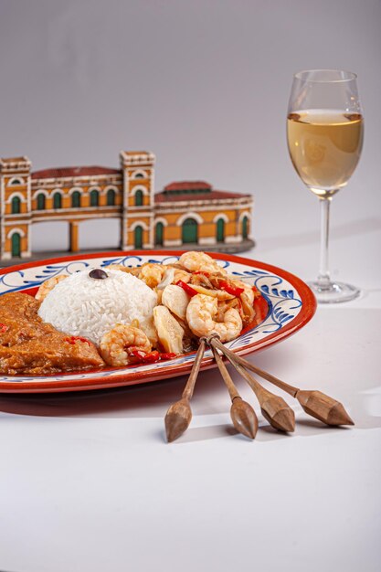 Morue des Açores avec riz aux crevettes et bouillie de poisson décorée de détails bilro et d'une réplique de la cuisine brésilienne du marché public de Florianopolis