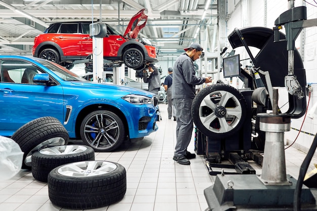 Moscou, Russie, 09.05.2019, un homme répare les voitures dans un atelier de réparation automobile, de nombreuses roues, BMW, montage des pneus