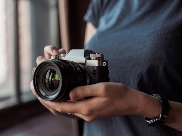 MOSCOU RUSSIE 14 MARS 2019 Appareil photo Fuji XT3 libre de jeune femme sur un fond de studio tenant un appareil photo sans miroir Le journaliste prend une photo