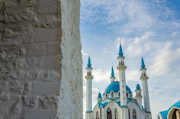 Une mosquée bleue et blanche avec un toit bleu et un mur de briques blanches.