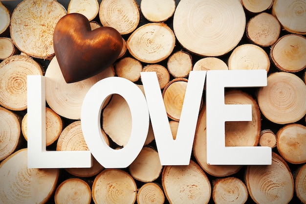 Photo mot d'amour et coeur brun sur fond de bûche de bois