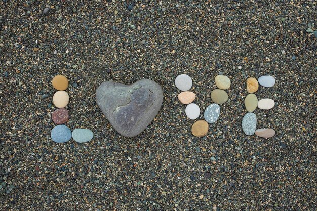 Mot amour fait de pierres sur une plage de sable