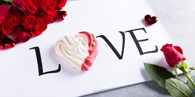 Mot d'amour avec meringue maison en forme de coeur avec des roses rouges. Concept de la Saint-Valentin, espace copie